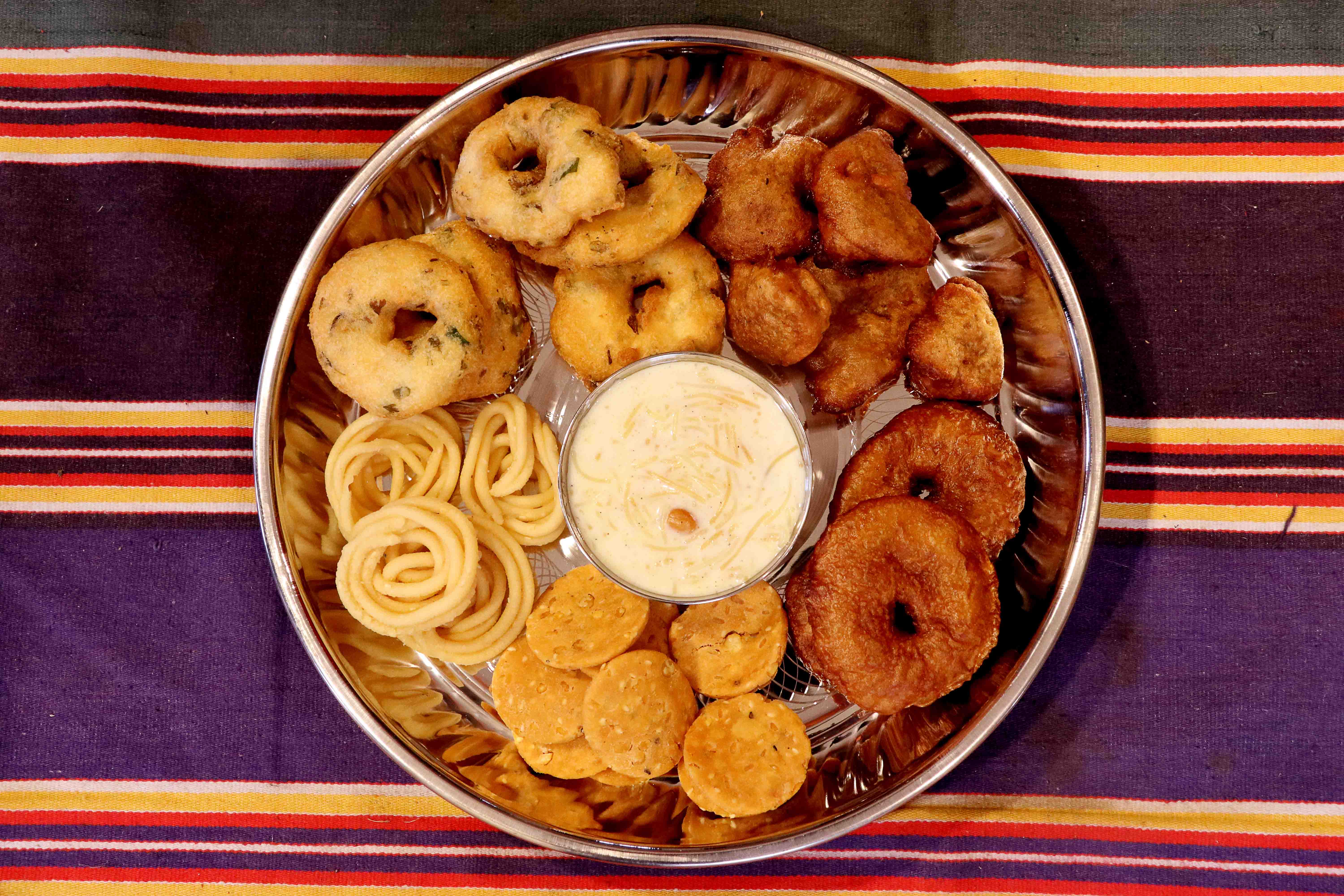 sweets and savories like payasam, vada arranged on a plate for offering to Hindu gods